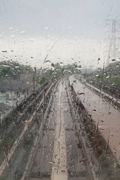 istock Drops of rain on a windows of a subway with train track as background 1299697080
