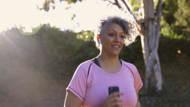 Senior black woman with wearable tech jogging