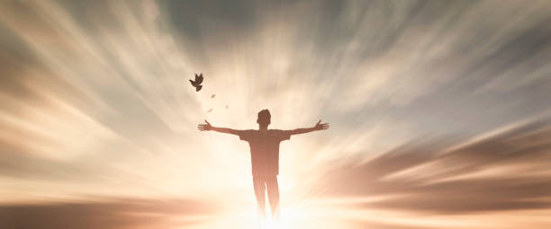 homme heureux lèvent la main adorent dieu dans la vue du matin. louange chrétienne de prière d’esprit sur le fond de vendredi saint. l’autonomisation masculine de confiance en soi sur la sagesse de force de concept de bras de mission ambitieuse - saint photos et images de collection