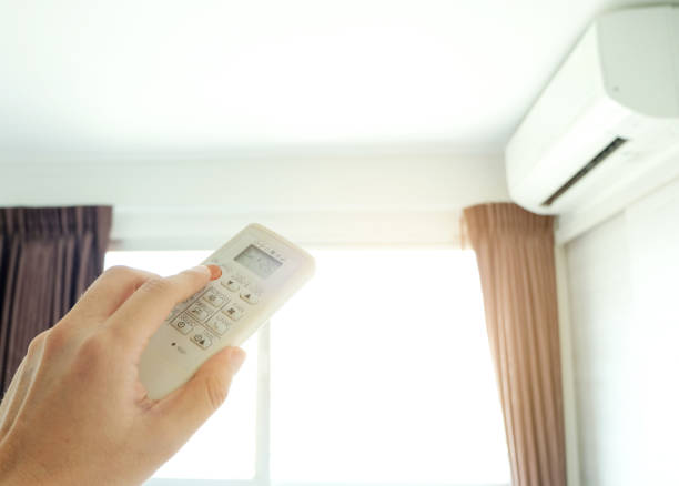 istock Man's hand using remote control open The air conditioner is cooled to 25 degrees Celsius in his bedroom. Health concepts and energy savings 1299704050