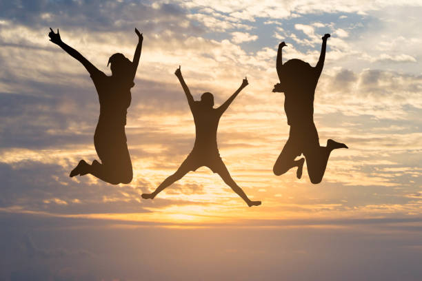 istock silhouette of happy women jumping 1299704279