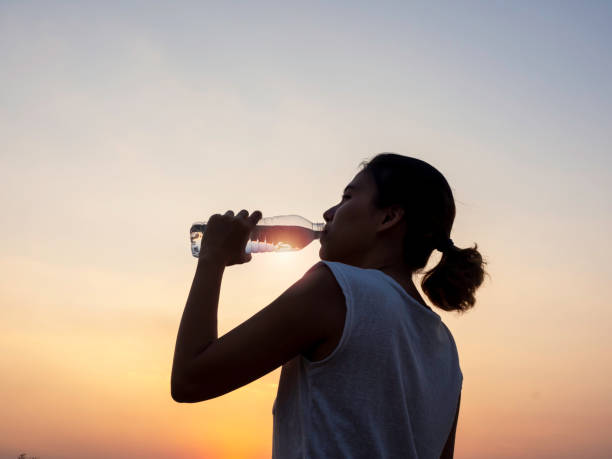 istock Asian woman drinking water after exercise. 1299704299