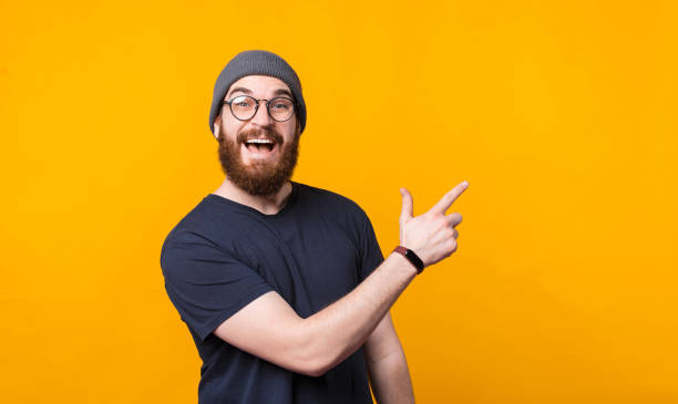 istock A surprised man is pointing at a free space and is looking at the camera 1299705982