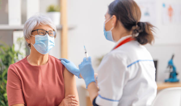 istock Doctor vaccinating a senior woman 1299711086