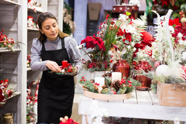 istock Flower shop worker making christmas compositions 1299712861
