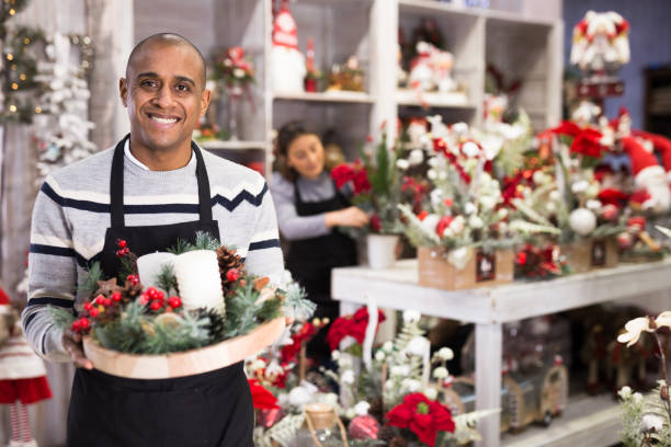 istock Flower shop owner holding christmas composition 1299712866