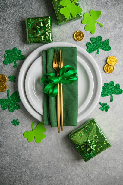 schöne festliche tischkulisse für st.patricks tag mit besteck und glückssymbolen. kopieren sie spase in der mitte. flach liegen. - tablesetting stock-fotos und bilder