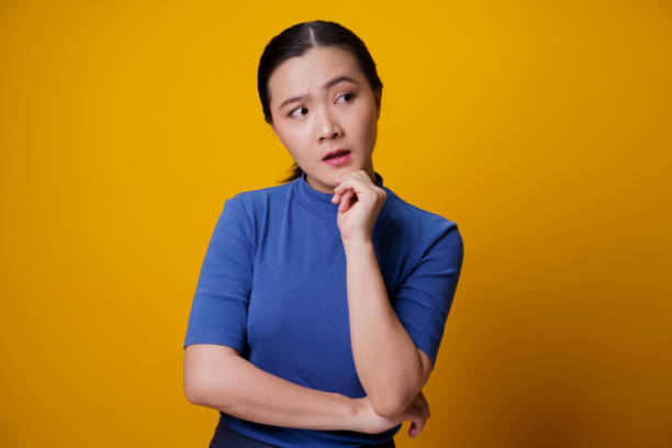 istock Confused Asian woman isolated on background. 1299714928
