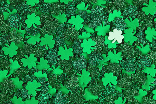 istock Shamrock confetti texture background with green and white lucky clovers 1299716451