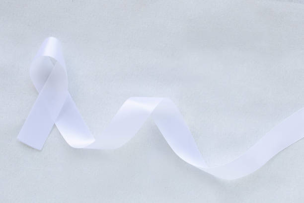 istock White pearl ribbon bow curl on white background with copy space. Lung Cancer Awareness, Mesothelioma and Retinoblastoma cancer symbol. Purity sign for Anti-violence against women, safe motherhood. 1299717219