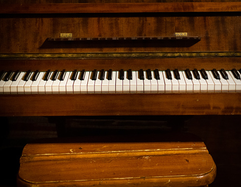 vintage piano witha chair on auction on display