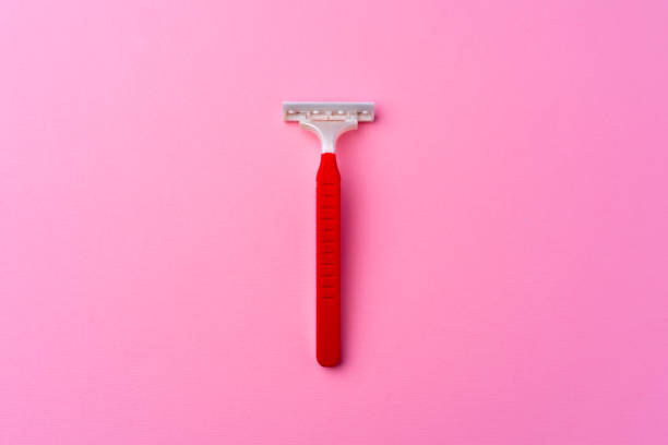istock Single disposable razor on pink background top view 1299717491