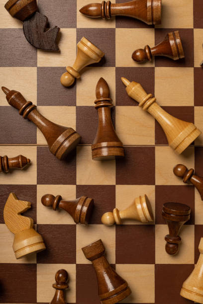 istock Chess pieces are scattered chaotically on a chessboard 1299718443