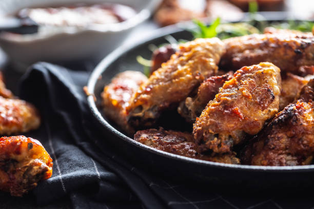 istock Chicken wings barbeque in a cast iron baking dish with BBQ sauce and rosemary 1299718761