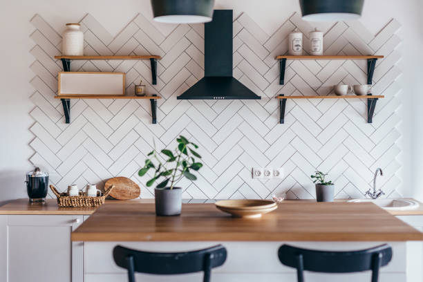 istock Modern new light interior of kitchen with white furniture and dining table. 1299719422