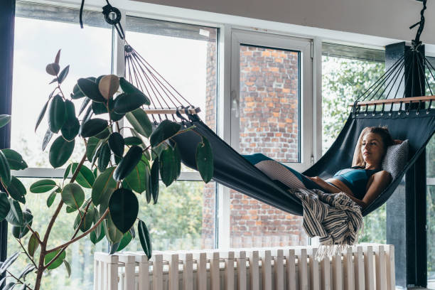 istock Woman is lying at home in a hammock and resting 1299719518