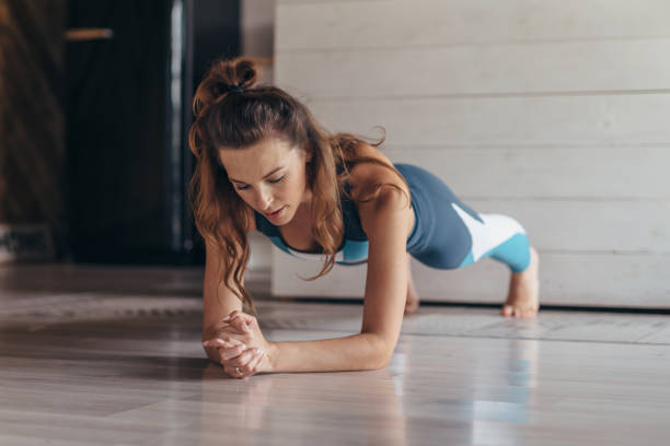 istock Fit woman doing plank exercise, workout at home 1299719522