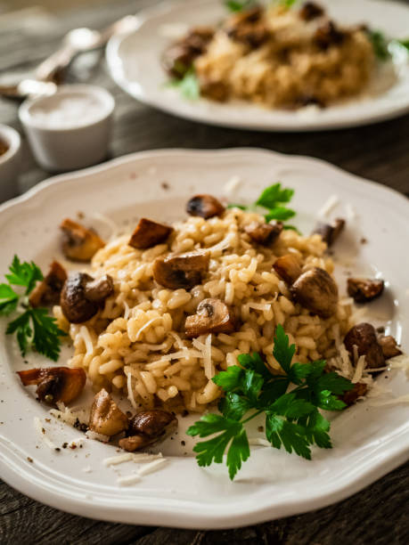 istock Risotto with champignon and parmesan on wooden table 1299724448