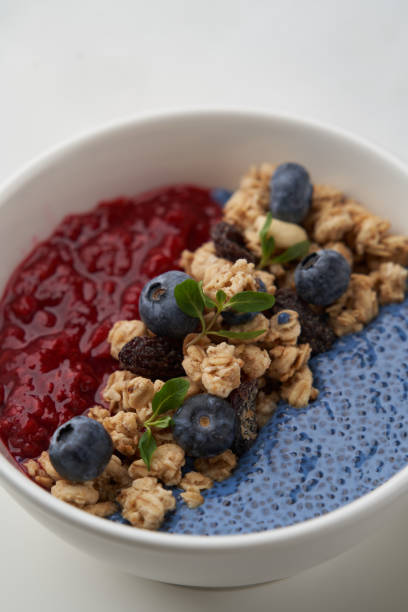 istock Breakfast smoothie bowl with granola on white background 1299726444