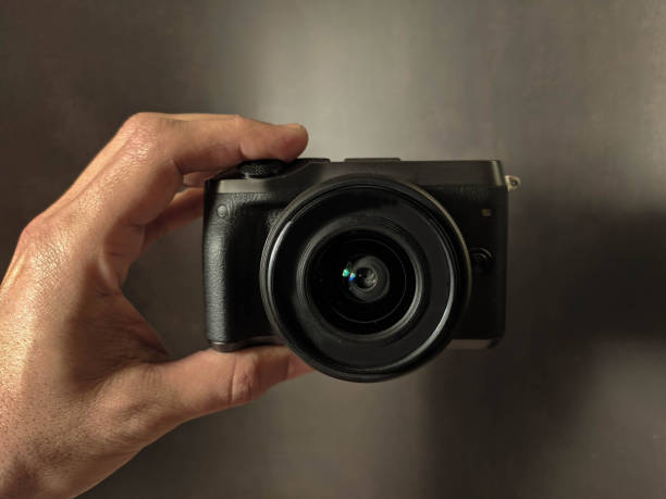 istock black photocamera in hand background 1299727536