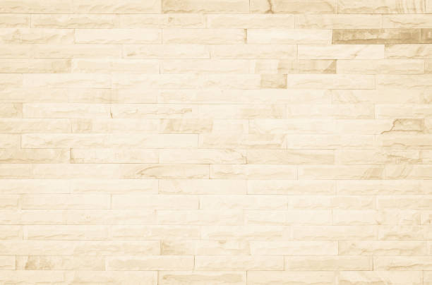 istock Empty background of wide cream brick wall texture. Beige old brown brick wall concrete or stone textured, wallpaper limestone abstract flooring/Grid uneven interior rock. Home decor design backdrop. 1299727679