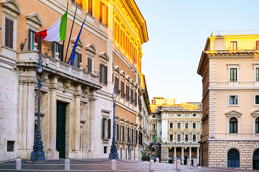 The main door and facade of the Montecitorio palace in the heart of Rome, seat of the Italian Chamber of Representatives. In the background the Piazza Colonna and the Alberto Sordi gallery. Image in high definition format.