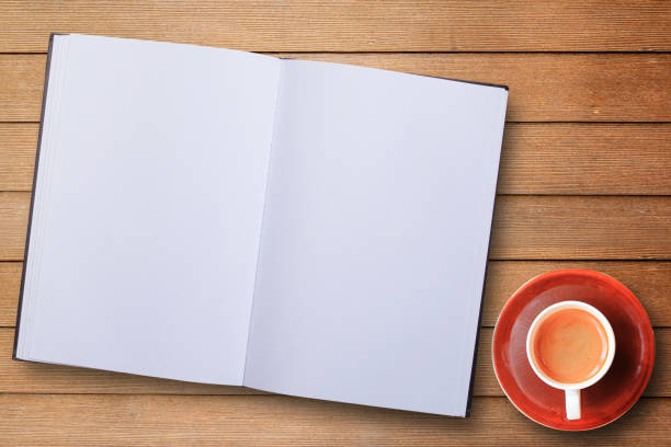 istock Blank notebook or notepad and coffee cup top view on wooden table background 1299729240