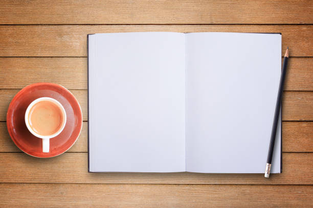 istock Blank notebook or notepad and coffee cup top view on wooden table background 1299729290