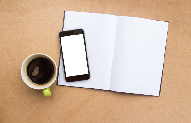 istock Blank notebook or notepad and coffee cup top view on wooden table background 1299729341