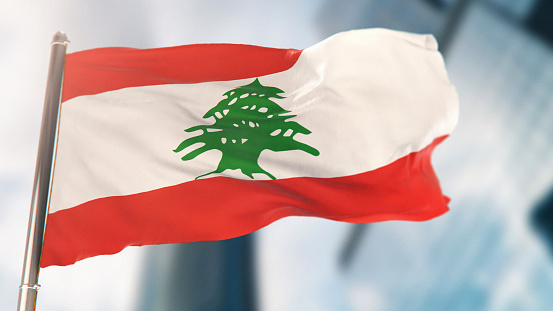 National Flag of Lebanon Against Defocused City Buildings