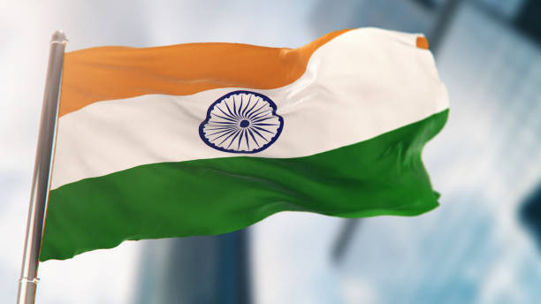 bandiera nazionale dell'india contro gli edifici della città sfocati - indian flag foto e immagini stock