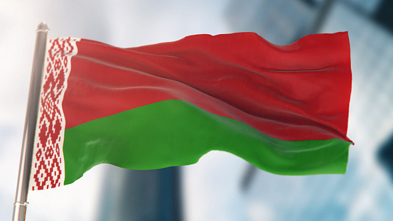 Bandera nacional de Bielorrusia contra los edificios desenfocados de la ciudad photo