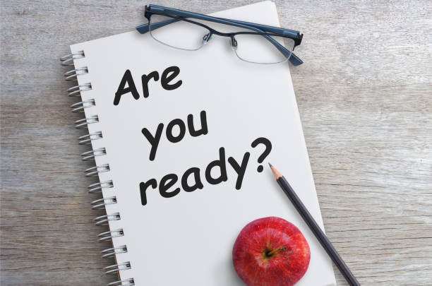 istock Question Are you ready on notebook page with pencil and red apples on wooden table 1299729569