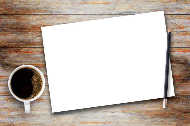 istock White paper,notepad or notebook with black pencil and cup of coffee on brown wood table background 1299730106