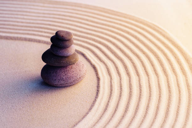 istock Meditation zen garden with stones on sand 1299730435