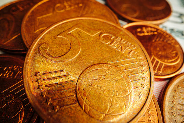 istock Euro cent coin on american dollar banknote close up 1299730540
