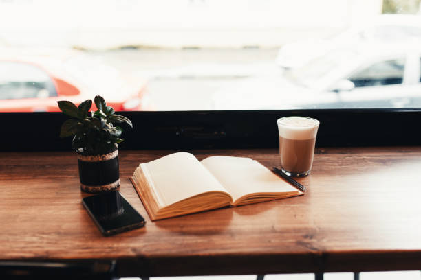 istock Cup of coffee, notebook, phone at table in cafe. Blurred background 1299733330