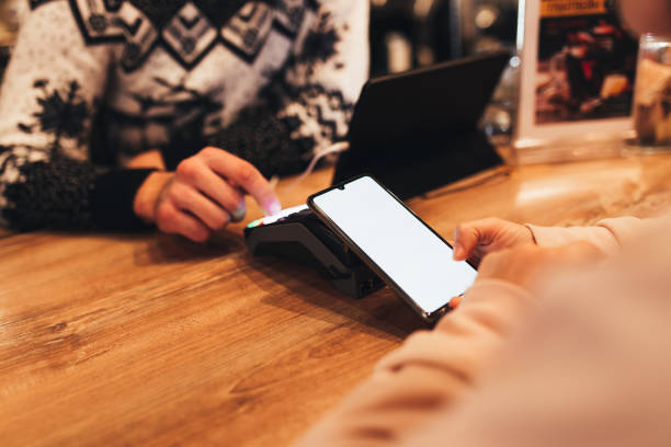 istock Cashless payment with NFC and phone in a cafe terminal. Blurred background 1299733342