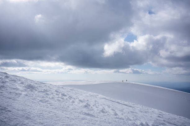 Hikers walking on the snowy plateau hill