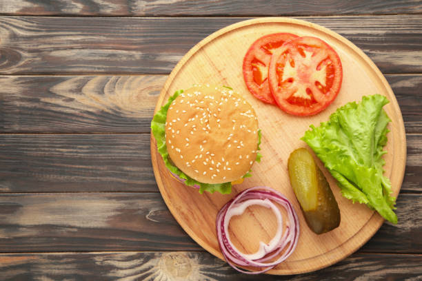 istock Homemade burger ingredients arranged on wooden background 1299734598