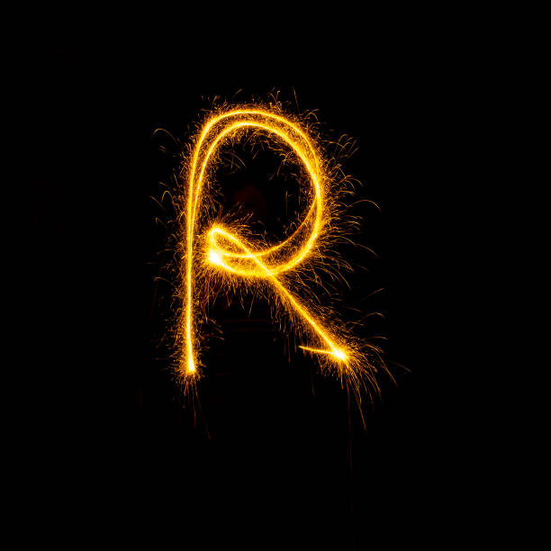 istock Alphabet sparklers on black background single letter 1299735315