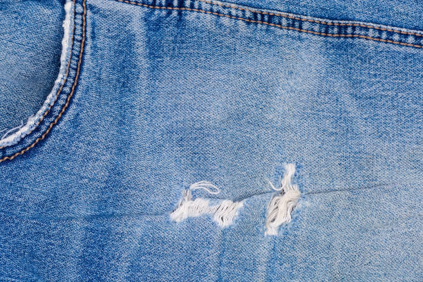 istock Rubbed places on blue jeans with frayed threads, fragment 1299735744