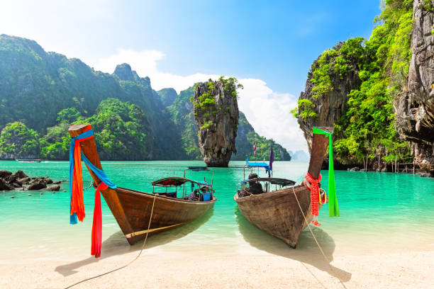 foto di viaggio dell'isola di james bond con la tradizionale barca a coda lunga in legno tailandese e la bellissima spiaggia di sabbia nella baia di phang nga, in thailandia. - tailandia foto e immagini stock