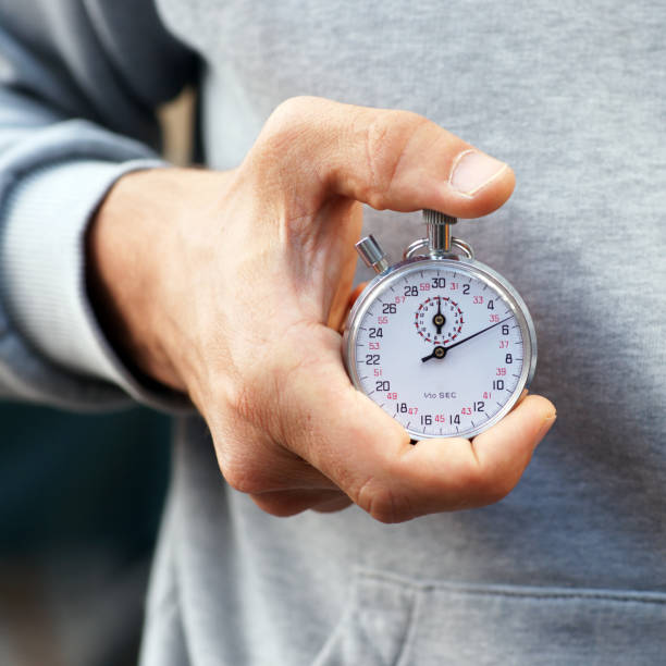 istock Trainer holds stopwatch in his hand and presses start and stop button - Close up 1299735913