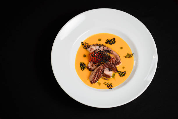 istock Vegetable soup with seafood and octopus on a black background 1299737098