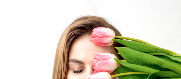 istock Young woman with pink tulips 1299738294