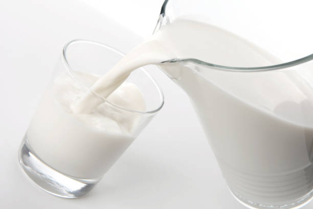 istock Fresh milk contained in a carafe is poured into a glass 1299738633