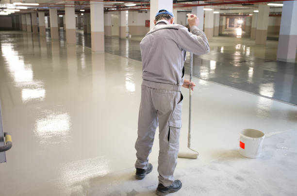 Putting non-slip layer on the floor of the underground parking garage Manual worker putting non-slip layer on the floor greasy water stock pictures, royalty-free photos & images