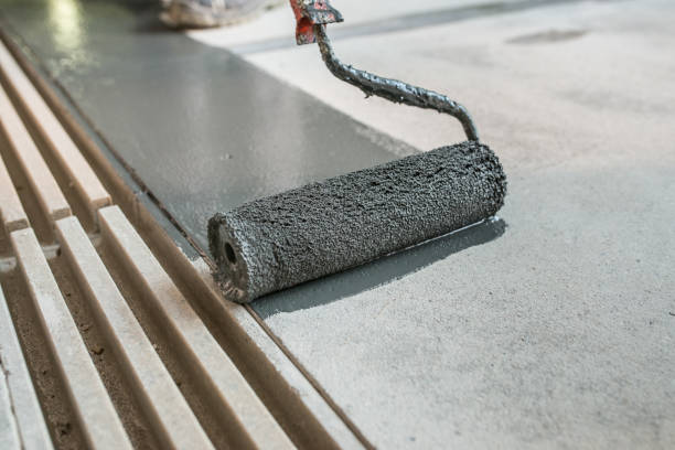 Putting non-slip layer on the floor Manual worker installing non slip surface on the floor next to the drain gully freshly painted road markings stock pictures, royalty-free photos & images