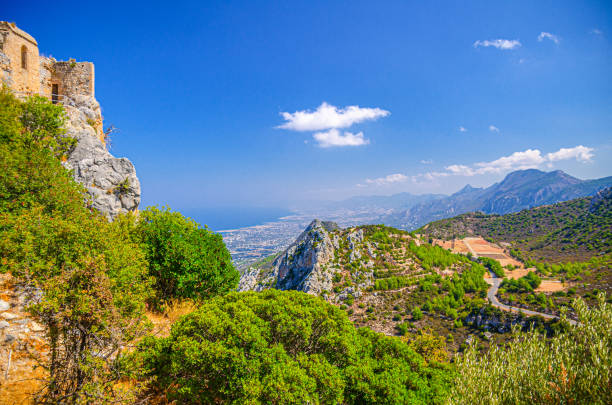 Aerial view of Kyrenia Girne mountain range and valley in front of Mediterranean sea, green trees on rock and ruins of Saint Hilarion Castle Saint Hilarion, Cyprus, September 27, 2017: Aerial view of Kyrenia Girne mountain range and valley in front of Mediterranean sea, green trees on rock and ruins of Saint Hilarion Castle foreground, blue sky in sunny day kyrenia photos stock pictures, royalty-free photos & images